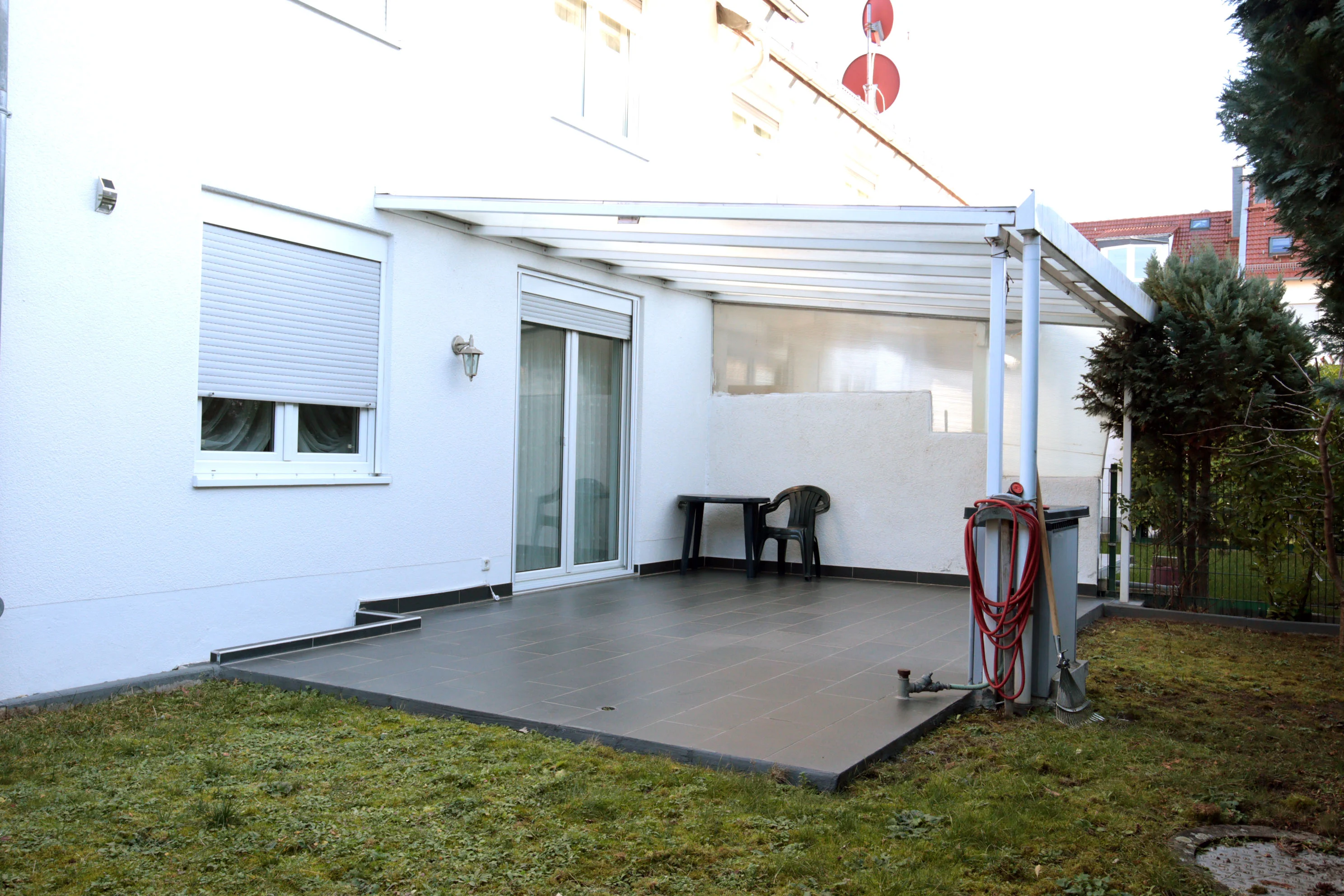 Überdachte Terrasse mit Regenwasserzisterne und Brunnen